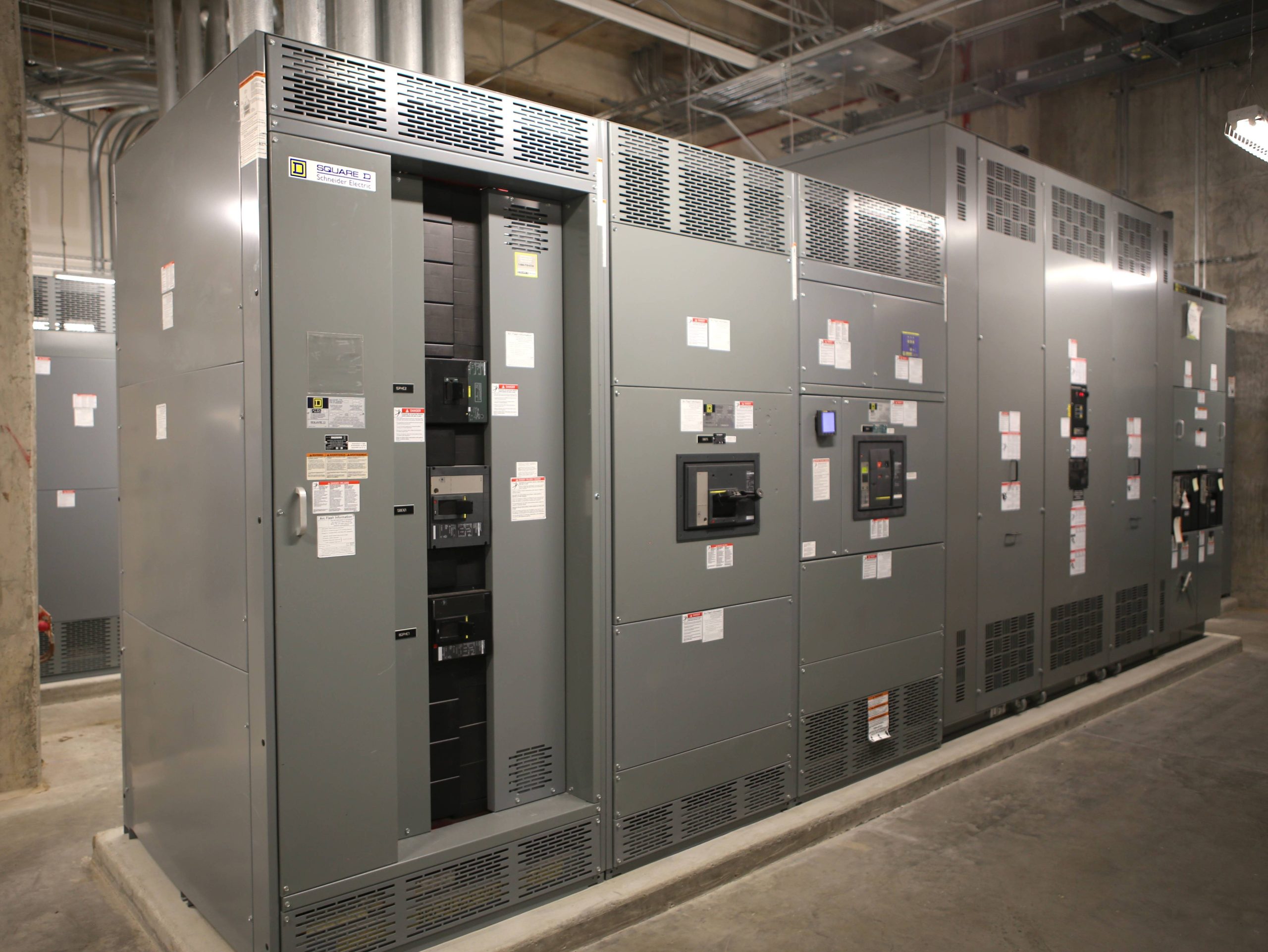 Electricista instalando cableado eléctrico en local comercial en fase de obra con canaletas visibles