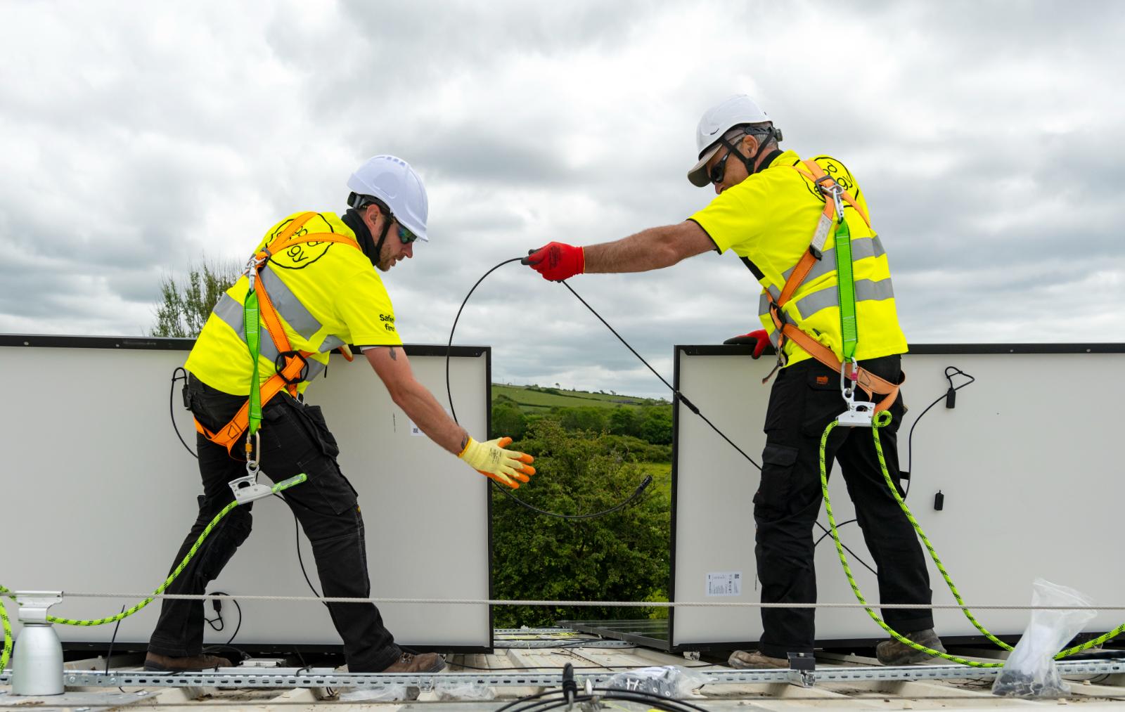 Técnico instalador fijando módulo fotovoltaico sobre estructura en tejado residencial